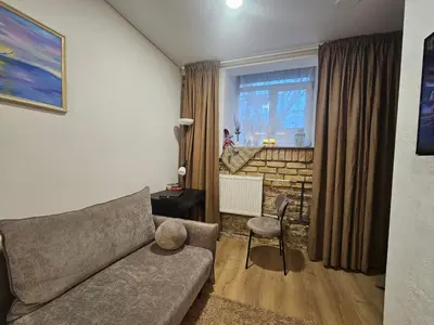 a living room with a couch and a chair at Urban oasis apartments in Vilnius