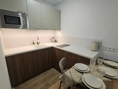 a kitchen with a table and chairs and a microwave at Urban oasis apartments in Vilnius
