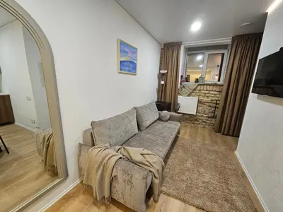 a living room with a couch and a living room with a staircase at Urban oasis apartments in Vilnius