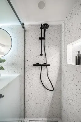 a shower in a bathroom with a wall at 8 Loft in Vilnius