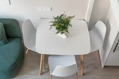 a white table with a plant on it next to a chair at 8 Loft in Vilnius