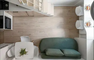 a living room with a green chair and stairs at 8 Loft in Vilnius