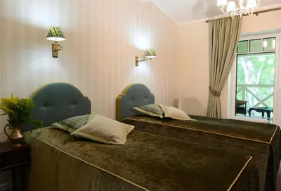 a bedroom with two beds and a window at Vila Klasika in Birštonas