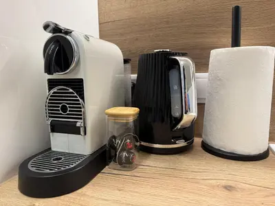 a coffee maker sitting on a counter next to a roll of paper towels at Centro apartamentai in Radviliškis