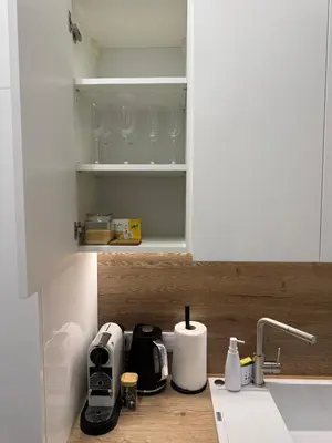a kitchen counter with white cabinets and a sink at Centro apartamentai in Radviliškis