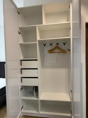 a closet with white shelves and a basketball hoop at Centro apartamentai in Radviliškis