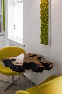 a table made out of a tree stump in a living room at Modern White Moss Apartment Kaunas Center in Kaunas