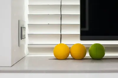 a group of three balls sitting in front of a microwave at Modern White Moss Apartment Kaunas Center in Kaunas