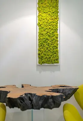 a table with a green ivy on a wall at Modern White Moss Apartment Kaunas Center in Kaunas