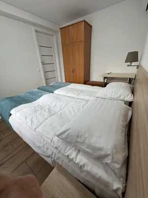 a bedroom with a large white bed and a desk at Florina namai 2 in Marijampolė