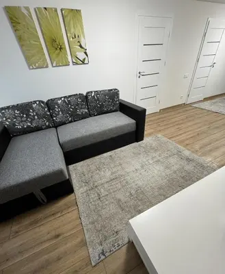 a living room with a couch and a table at Florina namai 2 in Marijampolė