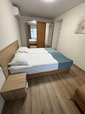 a bedroom with a large bed and wooden floors at Florina namai 2 in Marijampolė