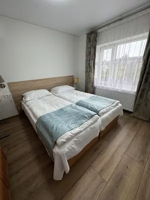 a large bed in a bedroom with a large window at Florina namai 2 in Marijampolė