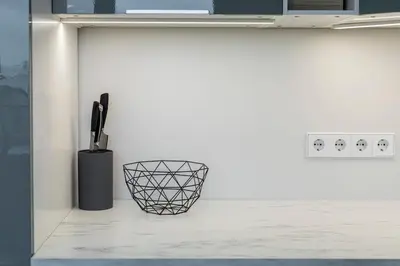 a kitchen with a white counter with a black basket at Spacious and Modern Apartment with Free Parking in Vilnius