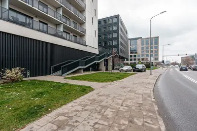 an empty sidewalk next to a street with buildings at Spacious and Modern Apartment with Free Parking in Vilnius
