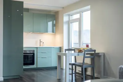 a kitchen with blue cabinets and a table and chairs at Spacious and Modern Apartment with Free Parking in Vilnius