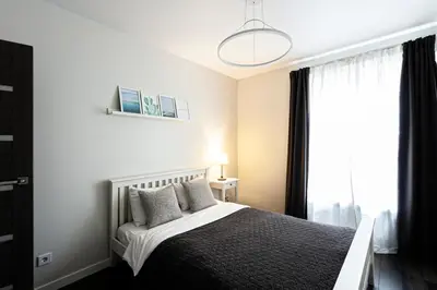 a bedroom with a bed and a window at Spacious and Modern Apartment with Free Parking in Vilnius