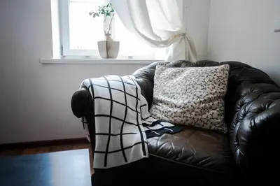 a black leather couch in a living room with a window at V 18 - Superior & Great views to Vokieciu street in Vilnius