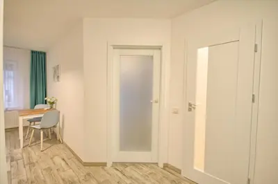 a room with a door and a table and a chair at Snow apartment in Druskininkai