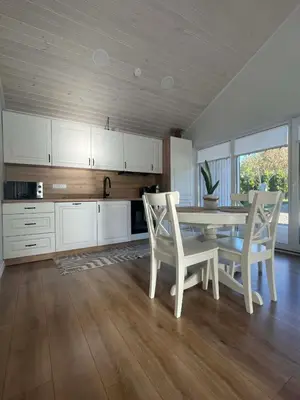 a kitchen with a table and chairs in a room at Cozy House By VP in Anykščiai