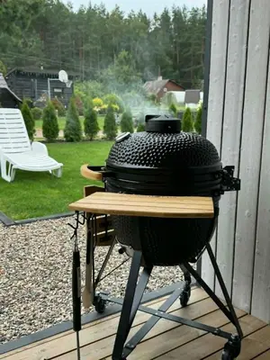 a grill sitting on a patio with a table at Cozy House By VP in Anykščiai