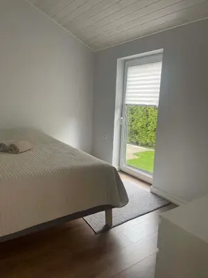 a bedroom with a bed and a large window at Cozy House By VP in Anykščiai