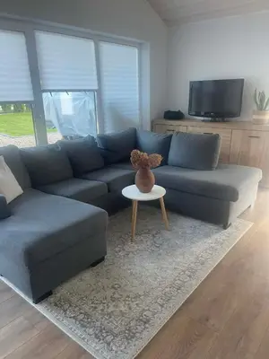 a living room with a blue couch and a table at Cozy House By VP in Anykščiai