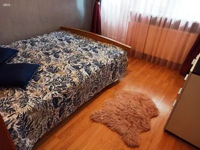 a bedroom with a bed and a rug on the floor at Jaukus būstas poilsiui in Kaunas