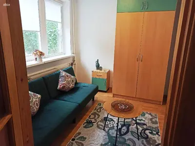 a living room with a green couch and a table at Jaukus būstas poilsiui in Kaunas