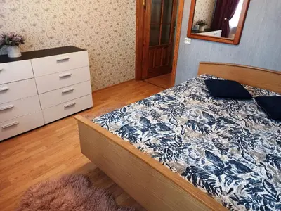 a bedroom with a bed and a dresser at Jaukus būstas poilsiui in Kaunas