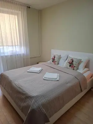 a bedroom with a large bed with two towels on it at Silver Vytauto Apartments in Šiauliai