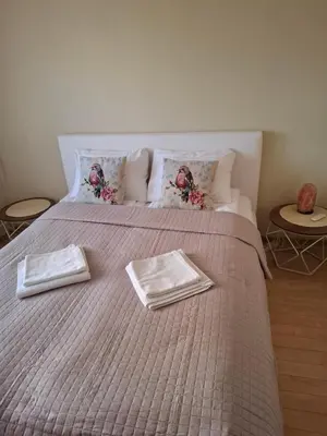 a large bed with two plates on top of it at Silver Vytauto Apartments in Šiauliai