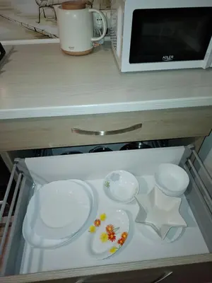 a shelf with plates and bowls in a microwave at Silver Vytauto Apartments in Šiauliai