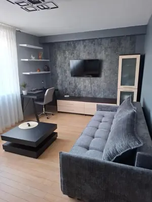 a living room with a couch and a desk at Silver Vytauto Apartments in Šiauliai