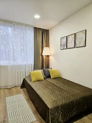 a bedroom with a bed and a large window at Airport & Station Stay Vilnius in VNO
