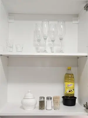 a shelf with wine glasses and a bottle on it at Airport & Station Stay Vilnius in VNO