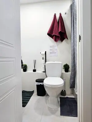 a bathroom with a white toilet in a room at Airport & Station Stay Vilnius in VNO