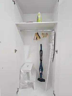 a white kitchen with a cabinet with a tool at Airport & Station Stay Vilnius in VNO
