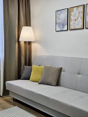 a gray couch with two pillows in a living room at Airport & Station Stay Vilnius in VNO