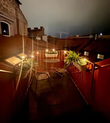 a balcony with a table and chairs and lights at St Michael's terrace in Vilnius