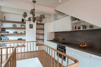 a kitchen with white cabinets and a staircase at St Michael's terrace in Vilnius