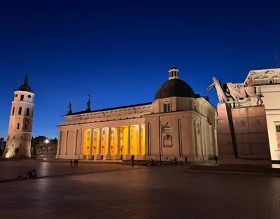 a large building with a clock tower at night at St Michael's terrace in Vilnius