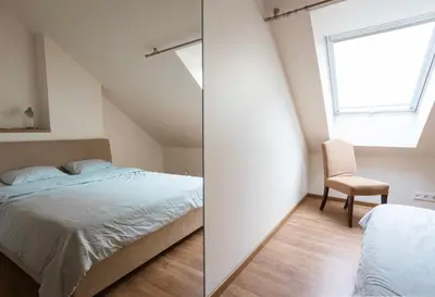 a bedroom with a bed and a window and a chair at St Michael's terrace in Vilnius