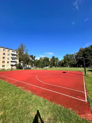 a tennis court in a park with a blue sky at Lina in Vilnius
