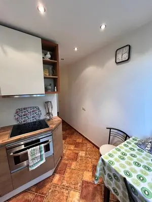 a kitchen with a stove top oven next to a table at Lina in Vilnius
