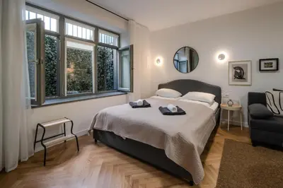 a bedroom with a bed and a couch and windows at Central Apartment in Kaunas with Free Parking in Kaunas