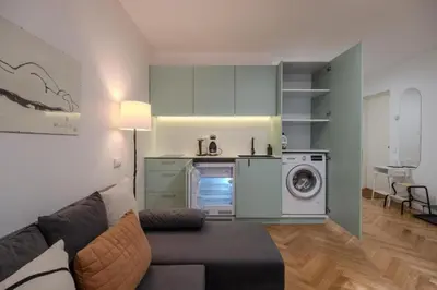a living room with a couch and a washing machine at Central Apartment in Kaunas with Free Parking in Kaunas