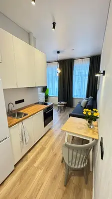a kitchen and living room with a table and a dining room at Cosy Sopenas home in Vilnius
