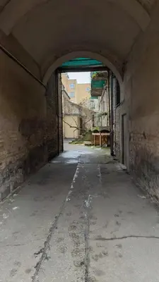 an empty alley with an archway in an old building at Central Breeze Flat x Self Check-in in Vilnius