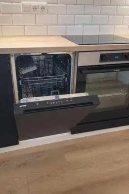 an open dishwasher sitting under a kitchen table at Central Breeze Flat x Self Check-in in Vilnius